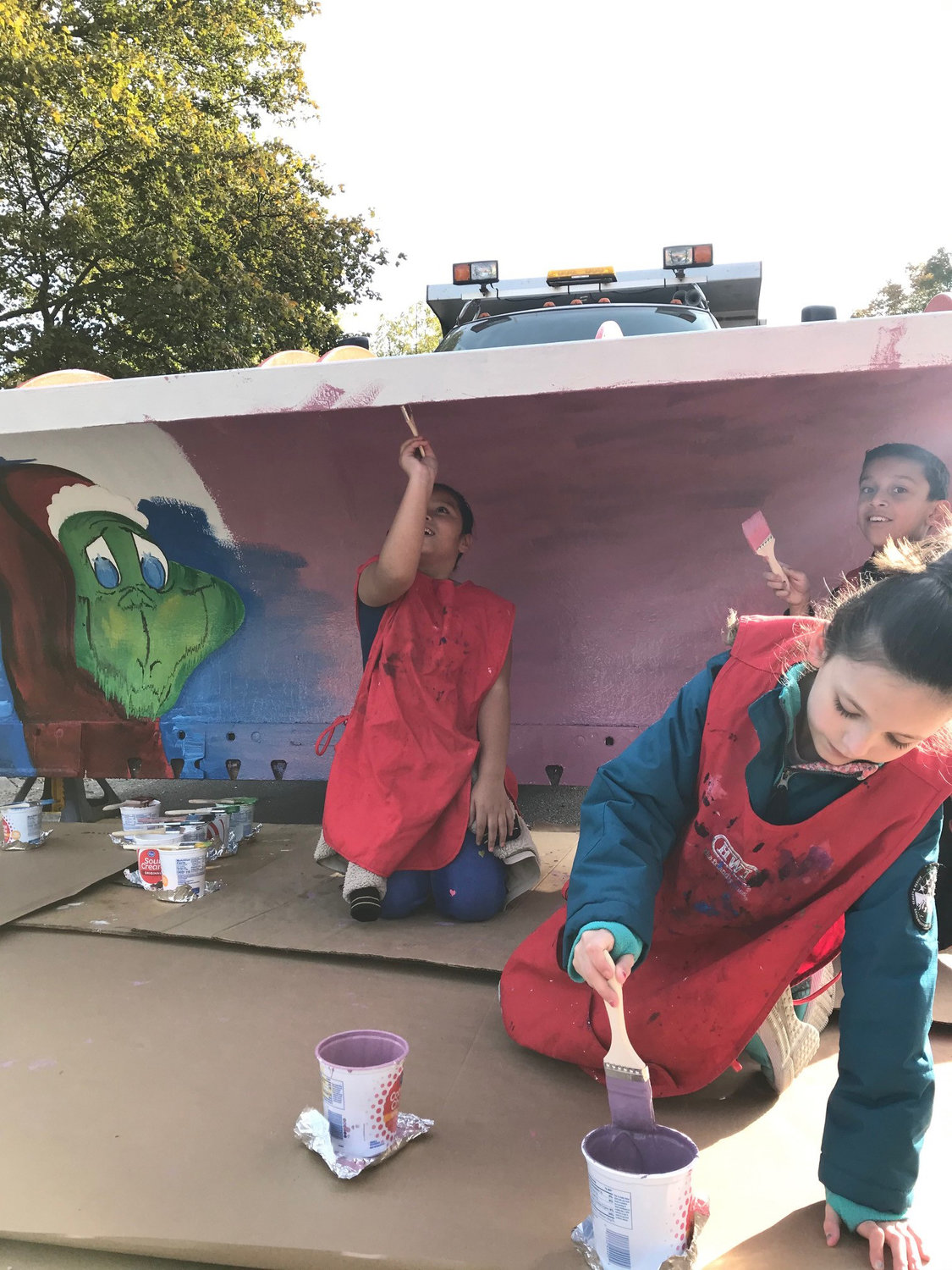 Yoselyn Gomez Castro, first from left, Briellah Grimes and Joel Conde Pascual paints a plow.